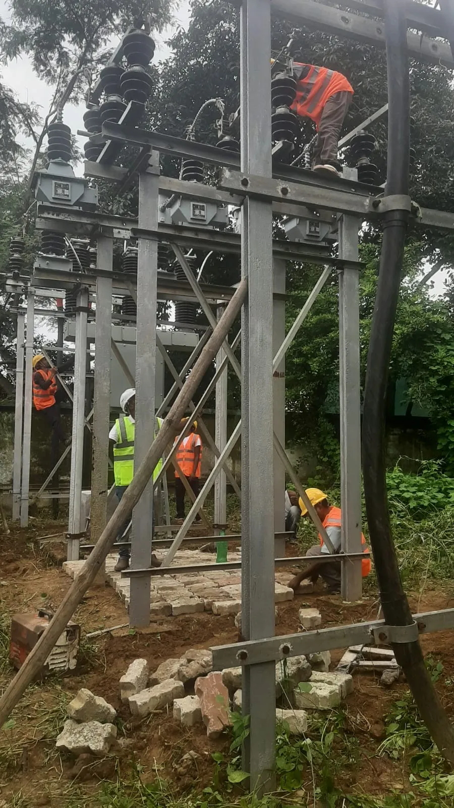 Worker connecting conductor into an insulator stack on a substation structure