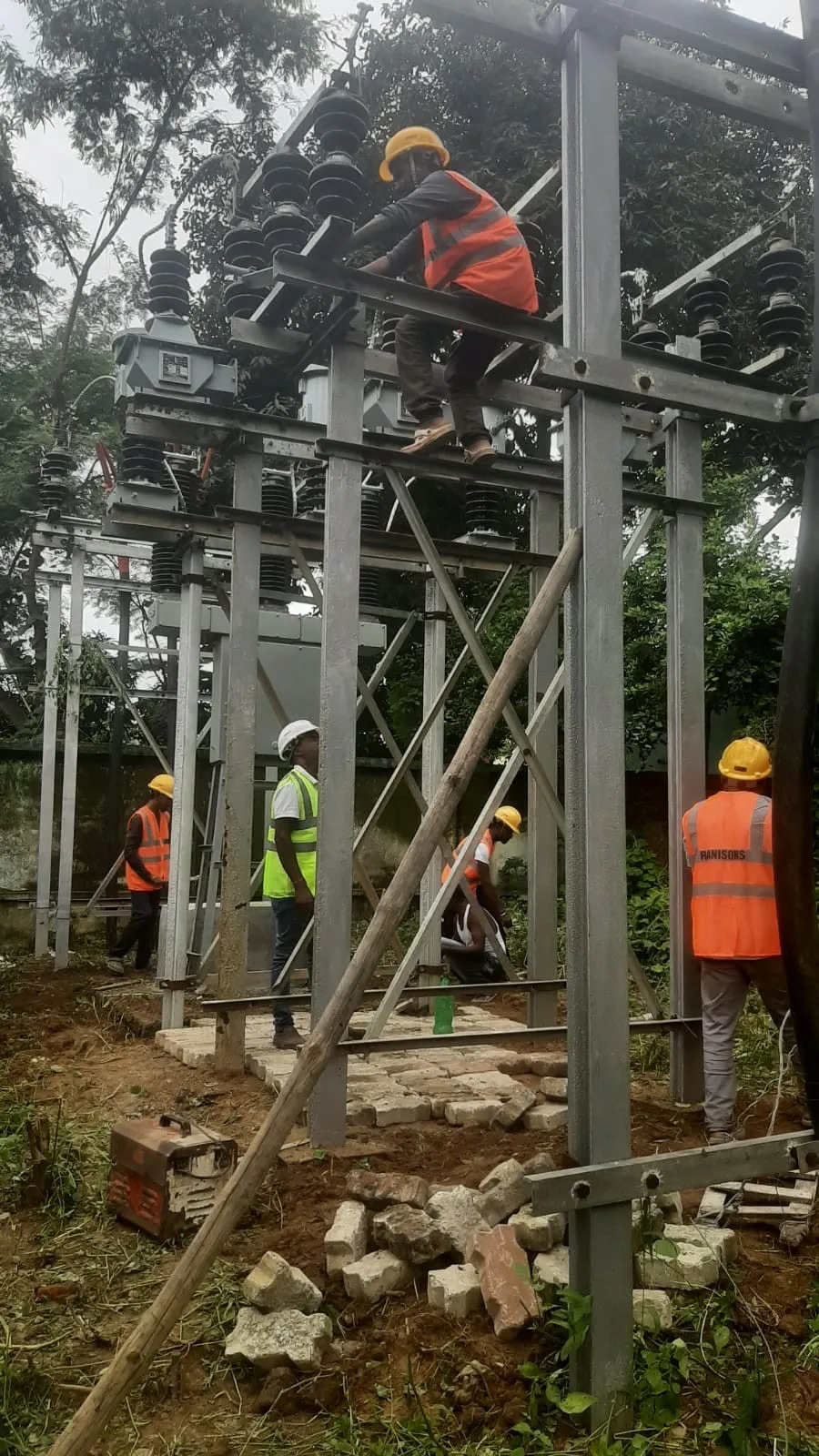 A bank of isolators installed on a substation gantry against an overcast sky