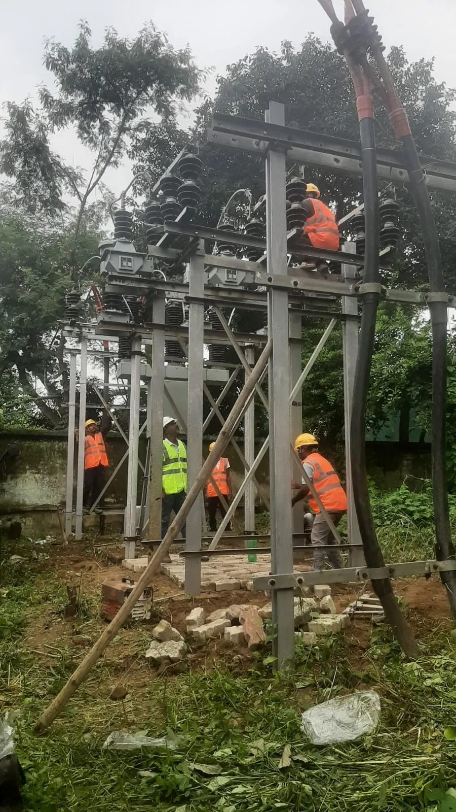 Worker at height fitting an isolator to a substation gantry