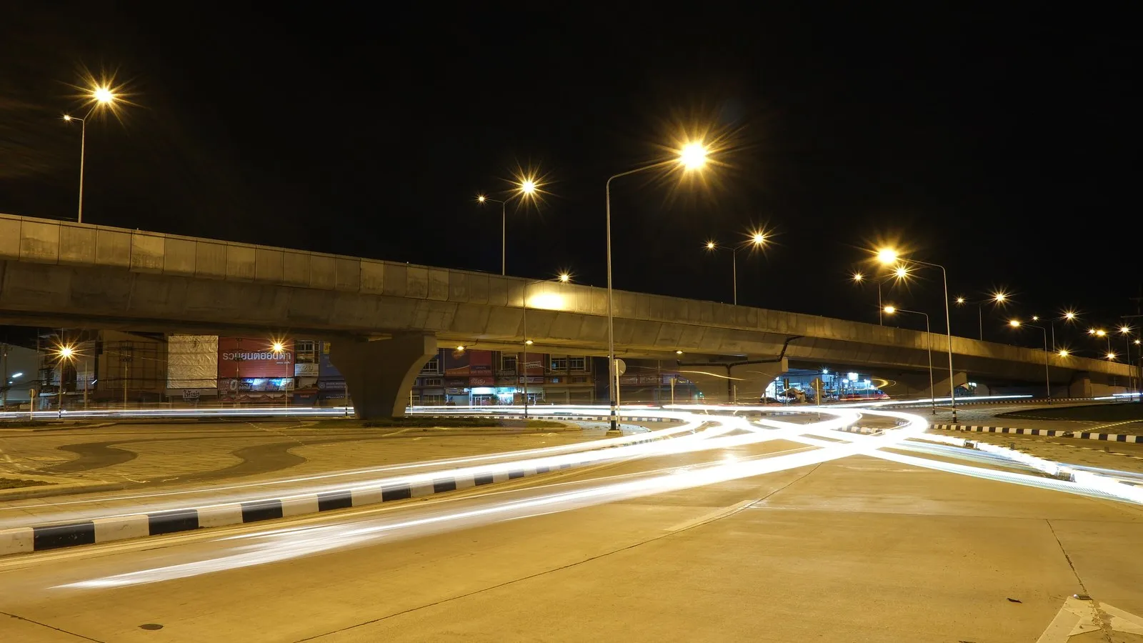 High-output LED floodlighting illuminating industrial stockyard and roadways at night